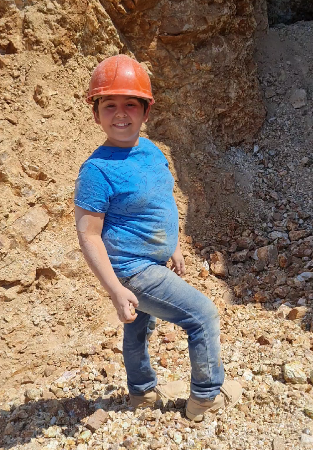 Child with hard hat smiling at the mine