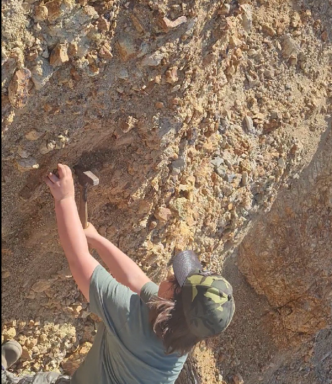 Person chiseling turquoise from the rock face