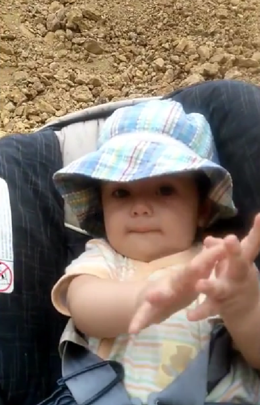 Baby at the mine site wearing a sun hat